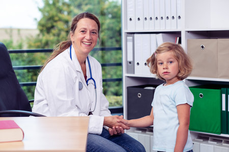 female pediatrician in white lab coat and the little patientの写真素材