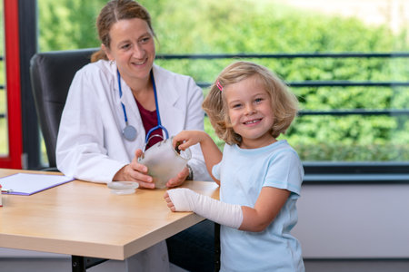 female pediatrician in white lab coat has candys for a little girlの写真素材