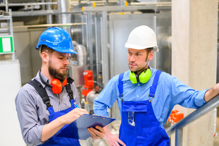 two worker in blue work clothes in industrial plantの写真素材