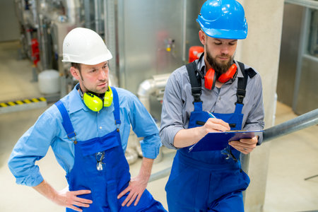 two worker in blue work clothes in industrial plantの写真素材