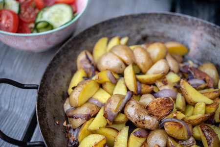 grilled potatos with onionin and salad iron panの写真素材