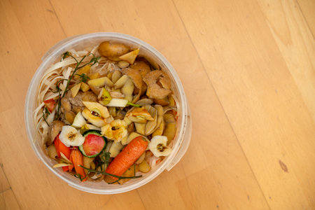 organic waste in bucket on wooden ground from topの写真素材