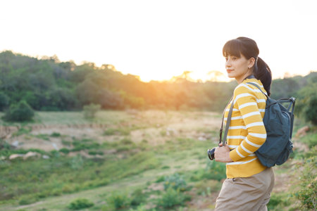 Young Woman in yellow sweaters standing for waiting take a photo sunset between travel in mountain for her vacation.の写真素材