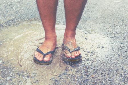 Foot's walking in the puddle after raining.の写真素材