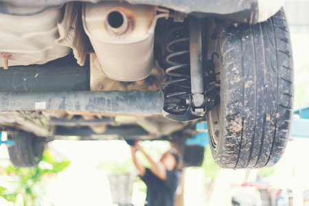 Shock absorbers checking at garage with many dust and mud on it.の写真素材