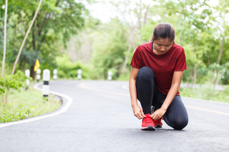 Woman runner tied her shoelace before start running.の写真素材