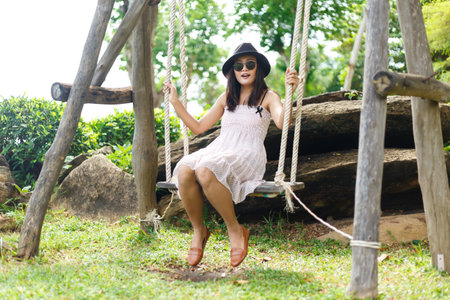 Woman playing a swing on green yardの写真素材