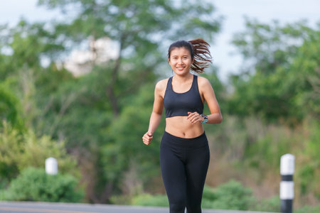 Woman Runner with black sport wear run in the green jungle.の写真素材