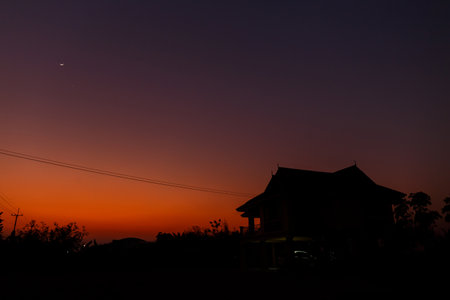 A silhouette of house under twilight sky.の写真素材