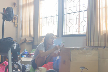 A woman cleaning and clearing unnecessary things out of her room.Natural flare include
