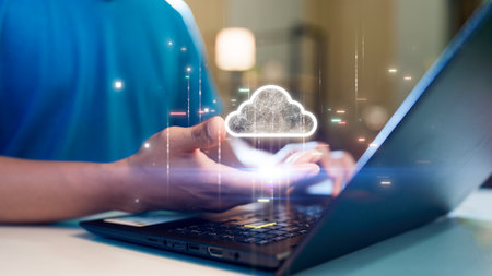 A person holding a glowing cloud icon above a laptop, symbolizing cloud computing, data storage, or digital technology concepts.の写真素材