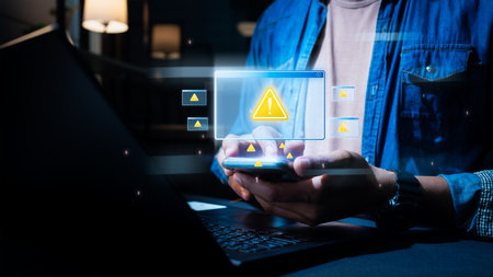 A person using a smartphone while receiving multiple cybersecurity warning alerts. Digital security risk icons appear in a futuristic interface, symbolizing hacking threats.の写真素材