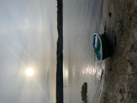 Fishing boat on the shore of the lake at sunset in summerの写真素材
