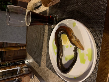 A glass of beer and a plate of mussels on the table