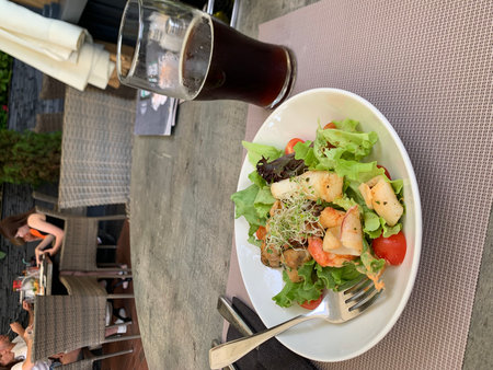 salad with fish and vegetables in a restaurant on the terraceの写真素材