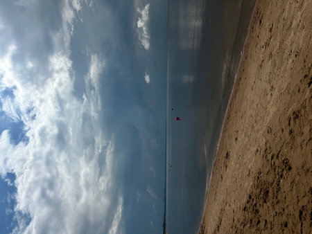 Parasailing on the beach in the morning with clouds and blue sky.の写真素材