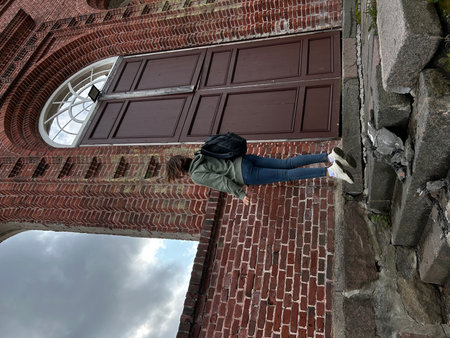 Young woman relaxing on the steps of an old church in Karelia.の写真素材