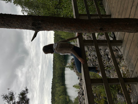 Young woman standing on the edge of a wooden bridge looking at the lake. Karelia, Ruskeala, Mountain Park, Marble Canyonの写真素材