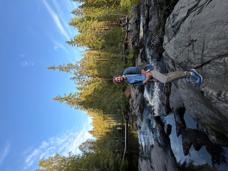 Rock climber on the edge of a cliff with a waterfall in the background. Ruskeala, Karelia, Marble Canyon, Mountain Parkの写真素材