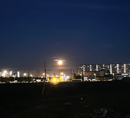construction site at night with full moon and building in the backgroundの写真素材