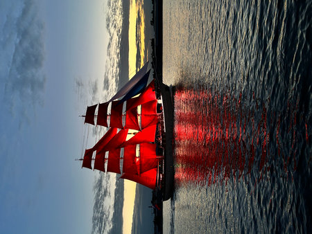 Sailing boat with red sails on the water in the evening. Scarlet Sails Festival, Saint Petersburg