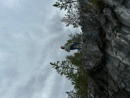 Man climbing on a rock in the forest. View from below.の写真素材