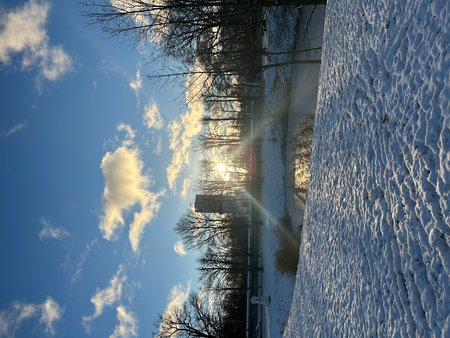 snowy winter landscape with snow covered trees and blue sky with cloudsの写真素材