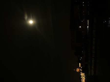 The moon in the night sky over the streets of Paris, Franceの写真素材
