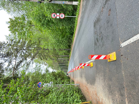 Road under construction with red and yellow warning tape, closeup of photoの写真素材