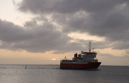 Small ferry calling at port in the sunriseの写真素材