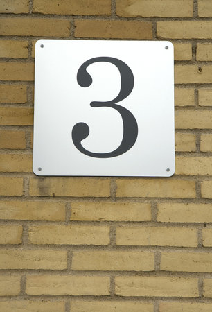 Number 3 on a yellow brick wall