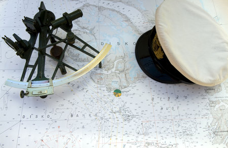 Sextant and peaked cap on a chart