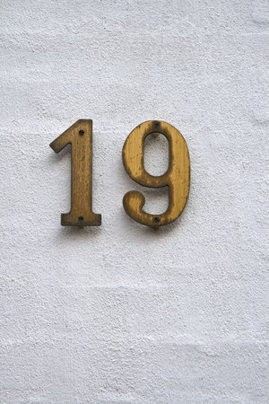 Number 19 on a white plastered wallの写真素材