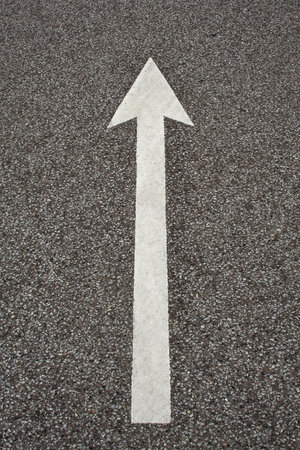 Arrow on asphalt. Shot from an old parking space
