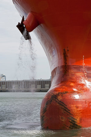 Bulbous bow on a red tanker cleaning anchorsの写真素材