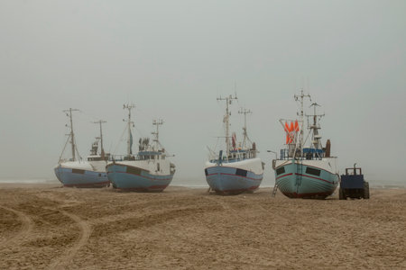 Fishing boats on the beach on a foggy morning