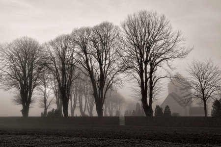 Black and white shot of a small church in the fogの写真素材