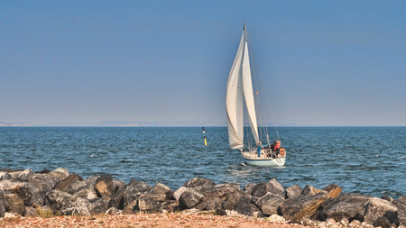 Sailboat leaving port on a clear day