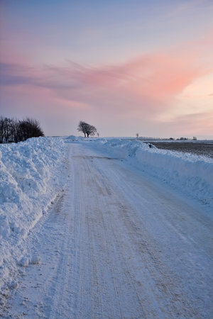 Country road in the snow at sunsetの写真素材