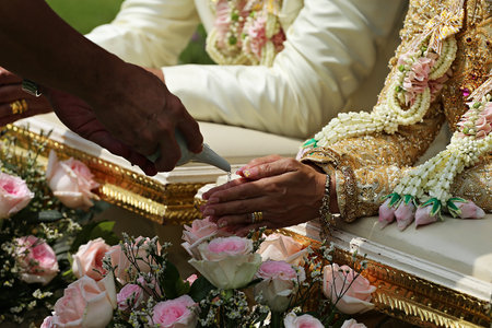 Pouring water from the conch shell into the bride's hands at a Thai weddingの写真素材