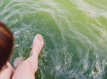 The girl bright foot moving in the water green color feeling relax on holiday.の写真素材