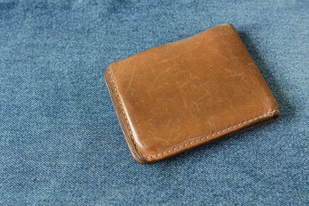 old vegetable leather wallet on blue denim background close upの写真素材