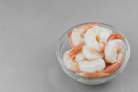 boiled shrimps in a glass bowl on cotton fabric backgroundの写真素材