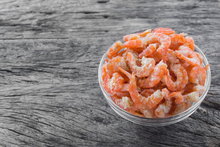 dried shrimp ingredient of many thai food in a glass bowl on old and crack wooden surface with copy space, close upの写真素材