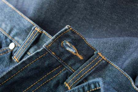 buttonhole of old denim on blue jeans backgroundの写真素材