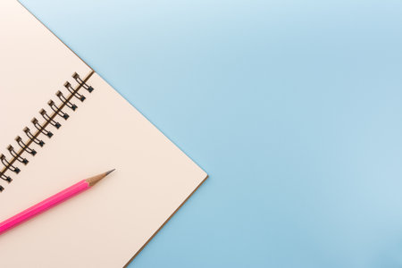 top view of blank notebook and pencil on light blue background with copy space. memo and planning concept.の写真素材
