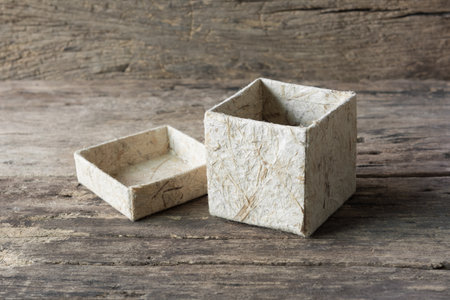 brown mulberry paper box for storage little object on old wooden board. nature material container concept.の写真素材