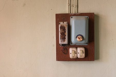 vintage switches and ceiling fan control on wooden box at dirty wall, copy space. old technology concept.の写真素材