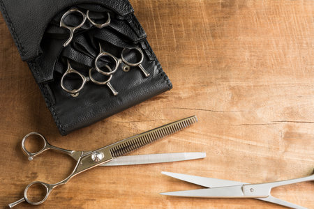 top view of hair cutting scissors set on old wooden table with copy space. grooming concept.の写真素材