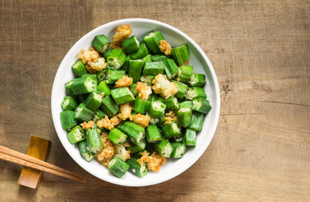 top view of stir-fried okra with salt in a ceramic dish on wooden table. homemade style healthy food concept.の写真素材